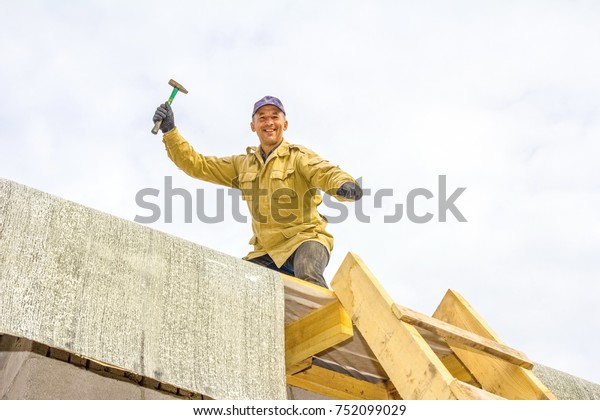 man-working-on-roof-waving-600w-752099029.jpg